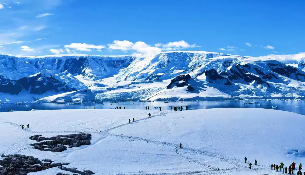 南极雪山、海湾与登陆队伍的风景照。