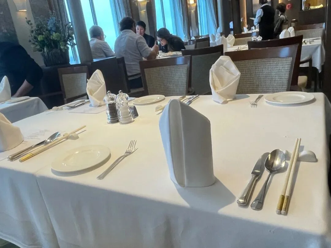 邮轮餐厅内整齐摆放的餐桌与窗外海面。