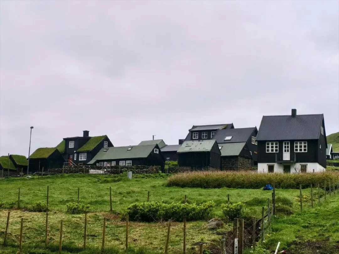 法罗群岛草地、黑色木屋与远处云雾。