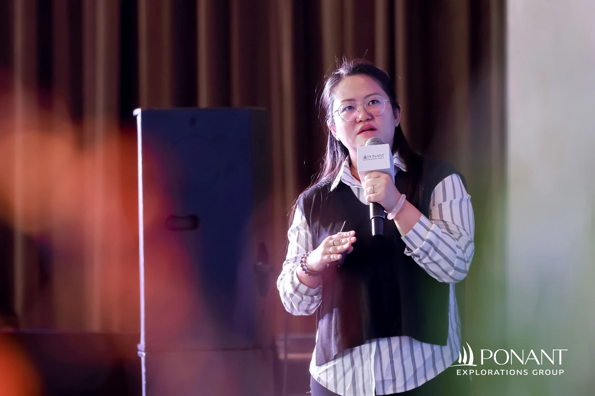 产品经理伊兰手持话筒在推介会现场发言